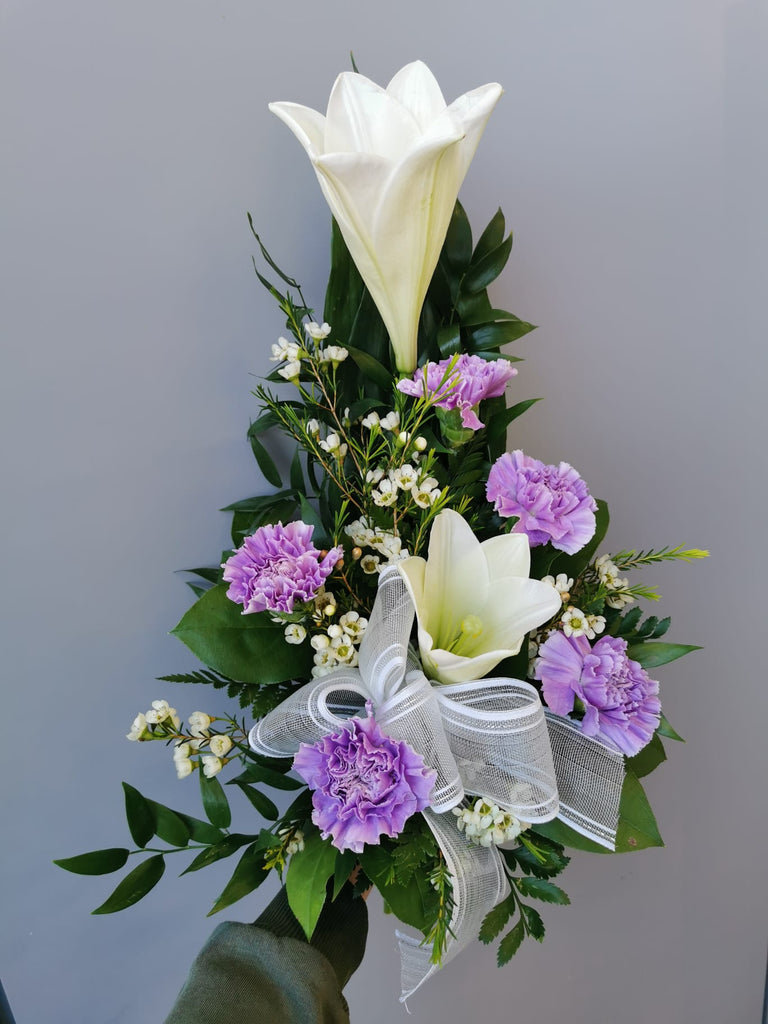 Kukkakimppu hautajaisiin. Valkoliljaa ja vaalean violettia neilikkaa.