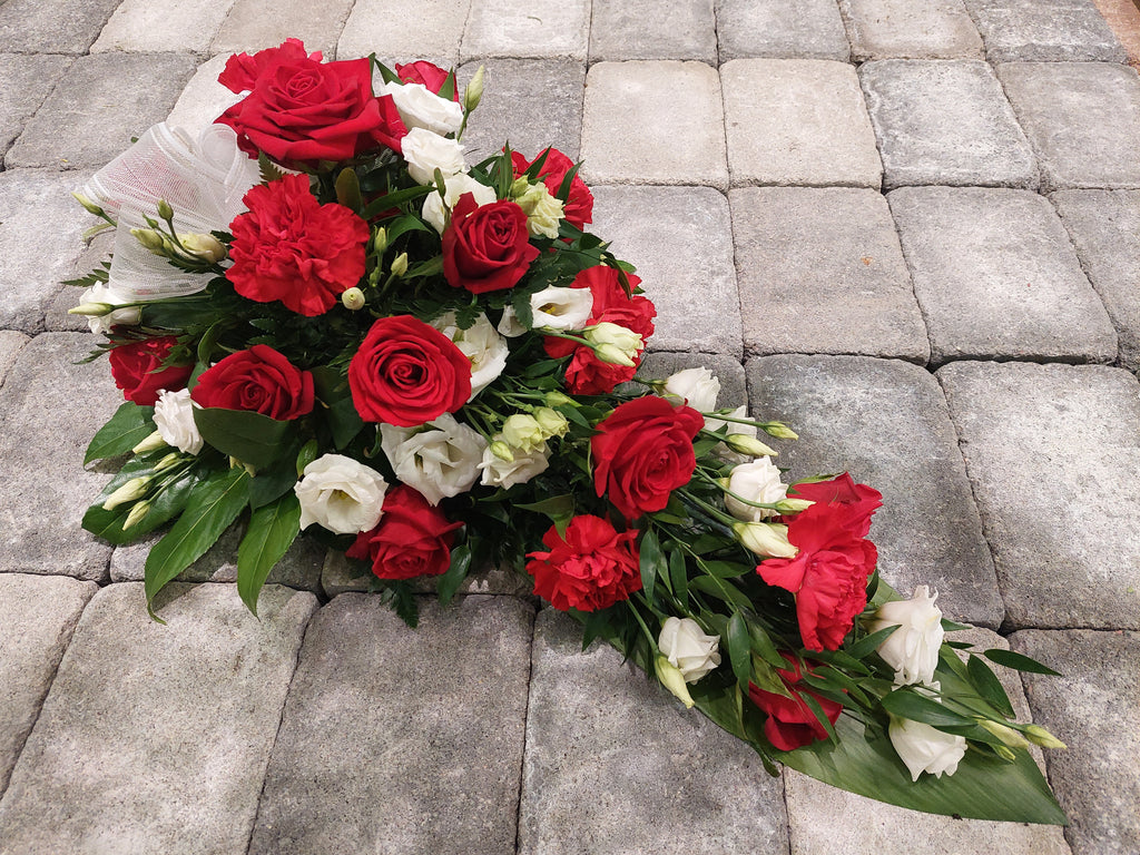 Kukkalaite hautajaisiin. Punaista ruusua ja valkoista eustomaa.