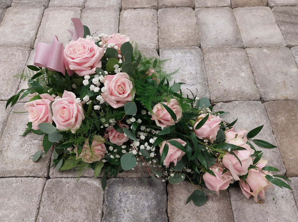 Kukkalaite hautajaisiin. Vaaleanpunaista ruusua ja valkoista harsokukkaa.