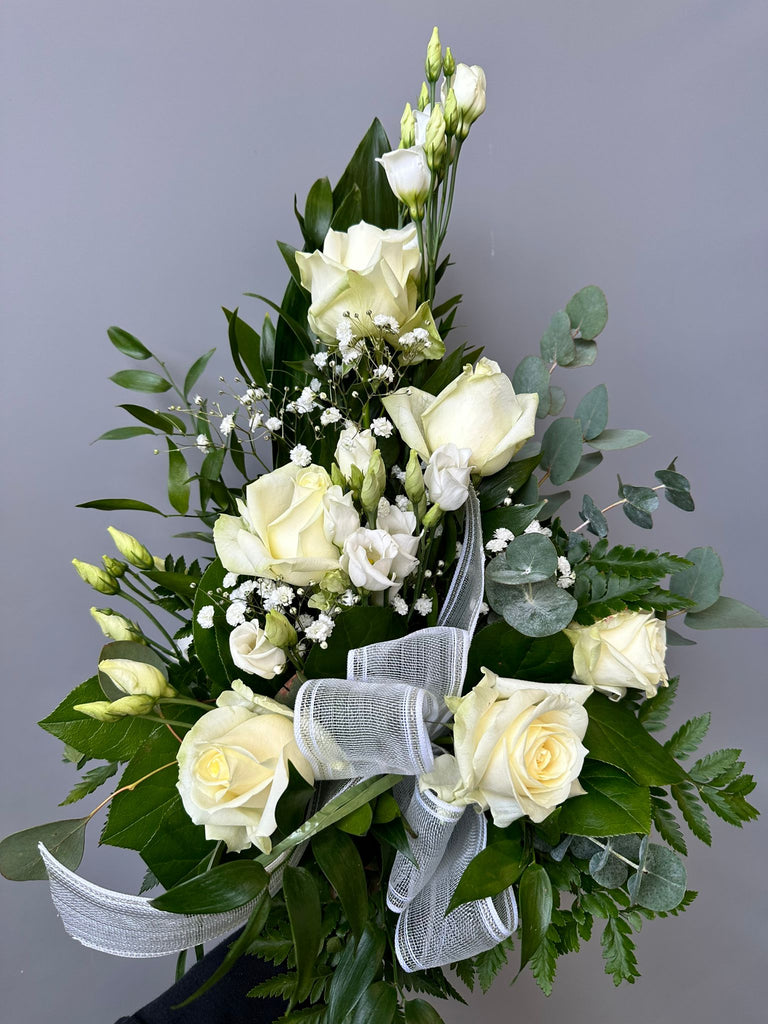 Kukkakimppu hautajaisiin. Valkoista ruusua ja valkoista eustomaa.