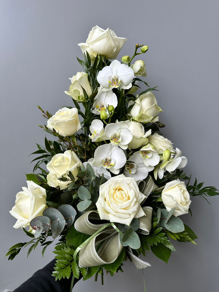 Kukkakimppu hautajaisiin. Valkoista ruusua ja orkideaa.