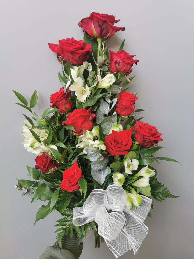 Kukkakimppu hautajaisiin. Punaista ruusua ja valkoista inkaliljaa.